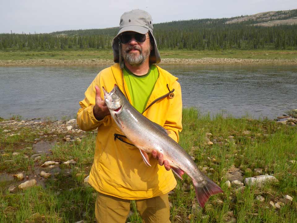 Jim holds an Arctic char caught in the cold water of the Horton River.