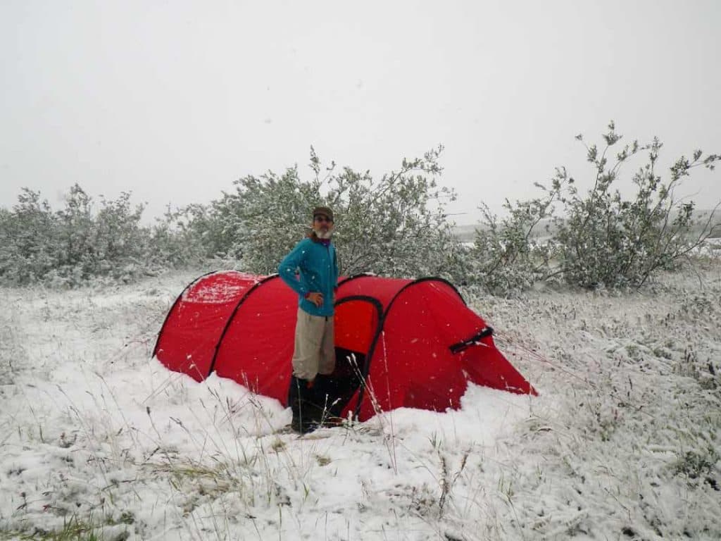 Brian Johnston stands next to his snow covered tent on July 20.